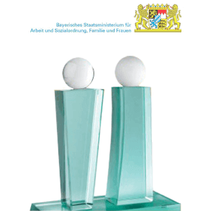 Two glass awards with spherical white tips stand on a glass base. Above them is the Bavarian coat of arms and the text Bavarian State Ministry of Labor and Social Affairs, Family and Women.